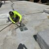Roofing professional inspecting a tile roof on a Scottsdale home under clear blue skies