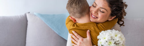 Mom hugging her son after receiving flowers from him