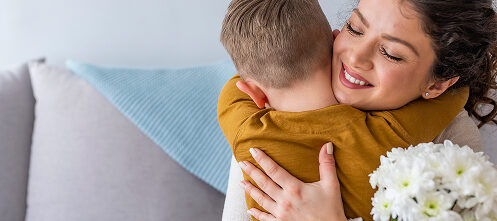 Mom hugging her son after receiving flowers from him