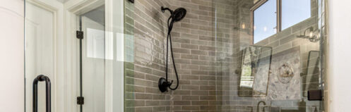 Remodeled bathroom with a rain shower head and green tile