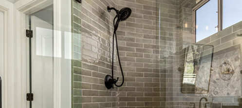 Remodeled bathroom with a rain shower head and green tile