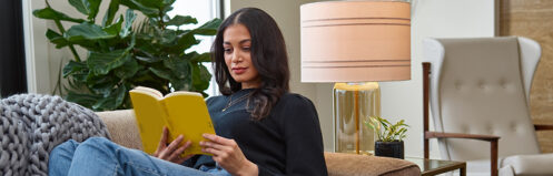 Woman reading a book relaxing on her couch